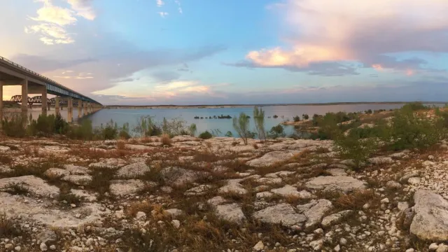 Sunset over Amistad Reservoir with Highway 90 bridge to left of photo going over the reservoir and i