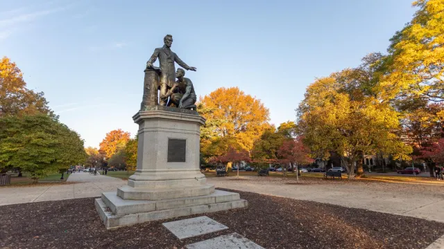 Bronze statue of Abraham Lincoln standing over an enslaved man rising from kneeling.