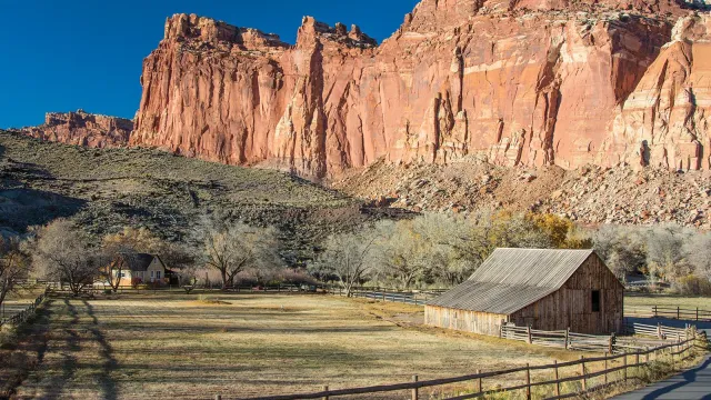 Wingate Sandstone cliffs behind historic barn and farmhouse