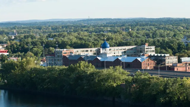 Blue dome atop a large factory behind a river