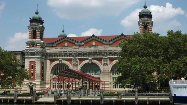 Beaux-Arts brick and limestone building with large arched windows and cupola-topped towers.