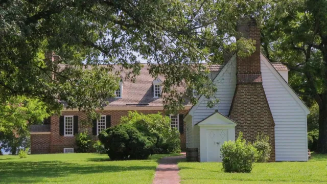 Two buildings surrounded by green foliage with a brick path leading to the buildings.