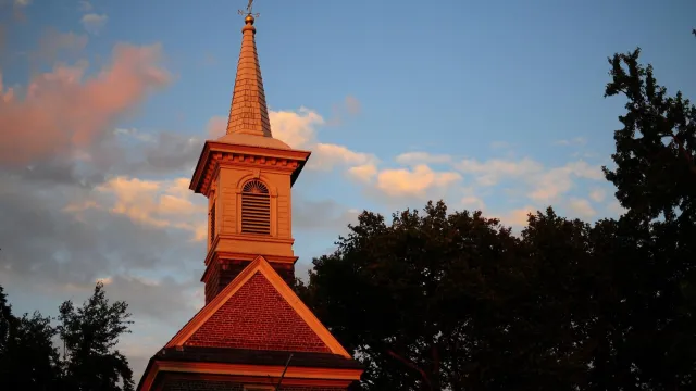 A color photo of the Gloria Dei Church steeple during a sunset in Philadelphia.