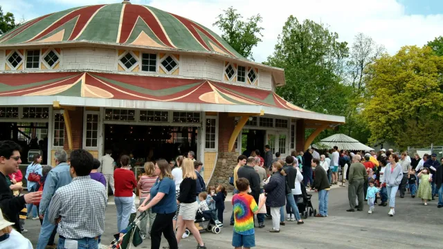 groups of families, adults and children strolling in Glen Echo Park near Carousel Building