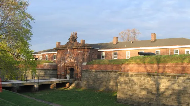 Bridge over dry moat leading into a gated fort.