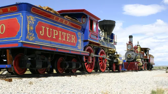 Two replica victorian age steam locomotives face each other on the original railroad grade