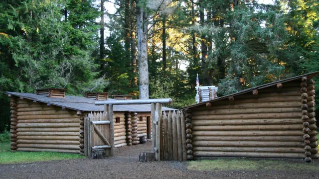 A fifty foot square wooden fort surrounded by tall trees in a forest.