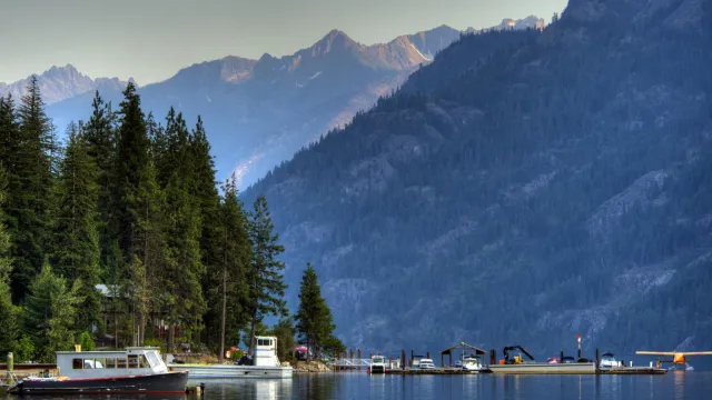 boats on the water with mountains and trees surrounding