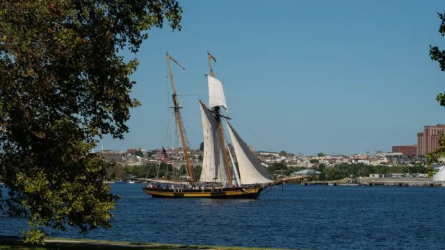 A tall ship sails on the water.