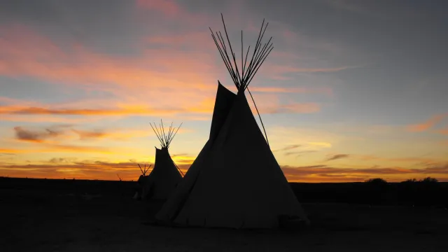 Cheyenne tipis backlite by sunset